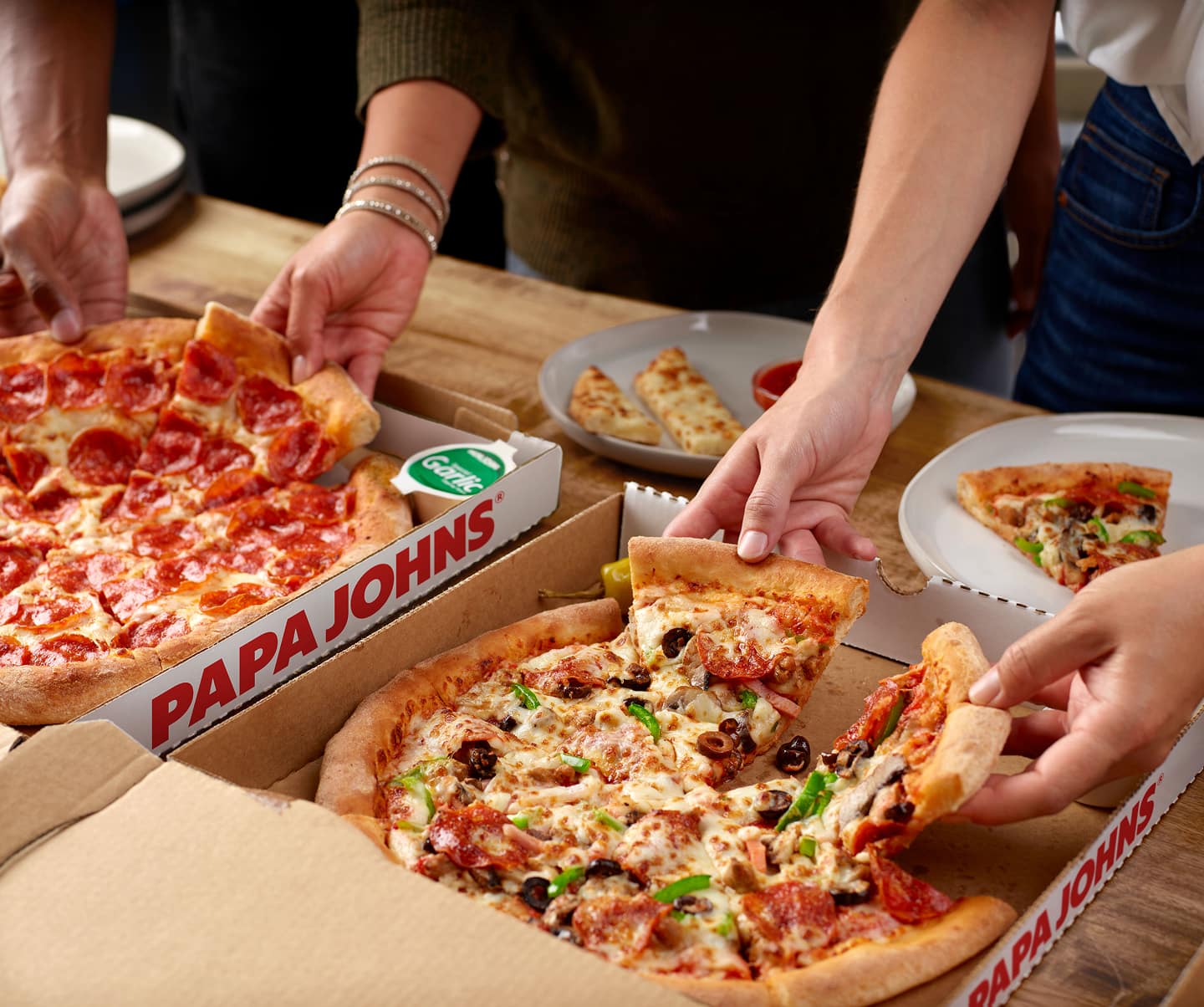 Papa Johns pizza in box with garlic sauce and pepperoncini