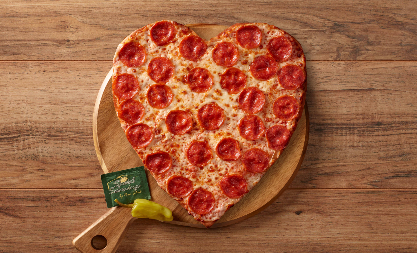 heart pizza with pepperonis on pizza slab