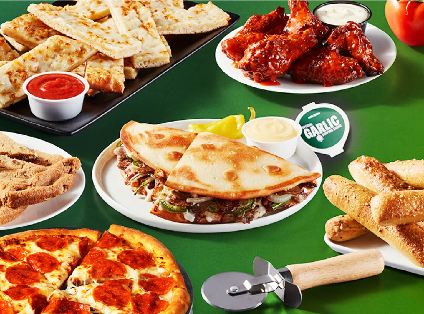 Un Papadia rodeado de Breadsticks, pizza, alitas de pollo, Cheesesticks y una galleta con chispas de chocolate