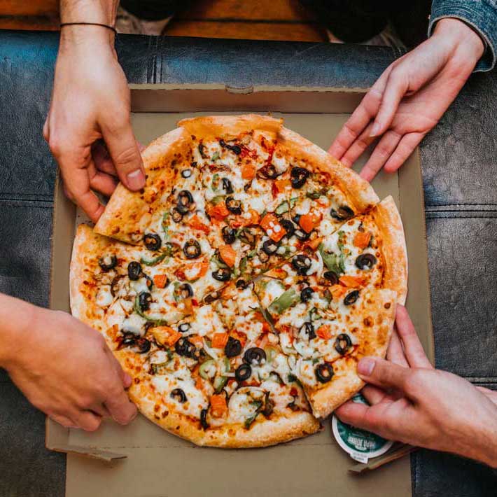 Hands sharing pizza