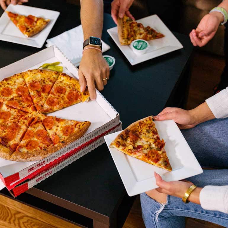 Grupo de personas compartiendo pizza